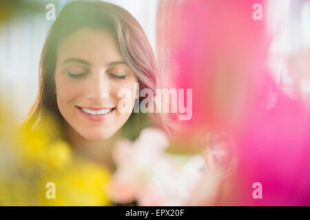 Femme derrière fleurs floues Banque D'Images