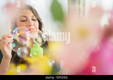Femme soufflant des bulles de savon Banque D'Images