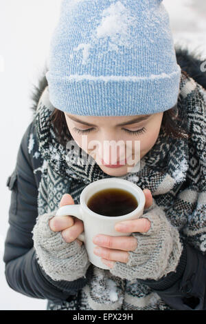 Woman with coffee mug in snow Banque D'Images