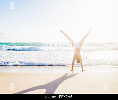 USA, Floride, Jupiter, woman doing handstand on beach Banque D'Images