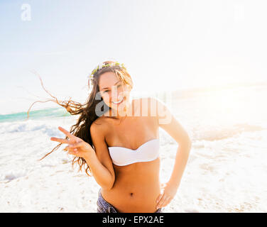 USA, Floride, Jupiter, Woman on beach faisant signe de victoire Banque D'Images