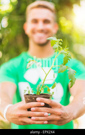 Portrait of young man holding potted plant Banque D'Images