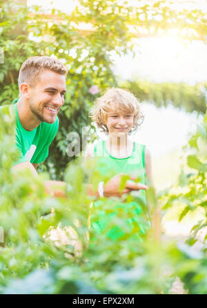 Boy (8-9) l'apprentissage sur les plantes dans le jardin Banque D'Images