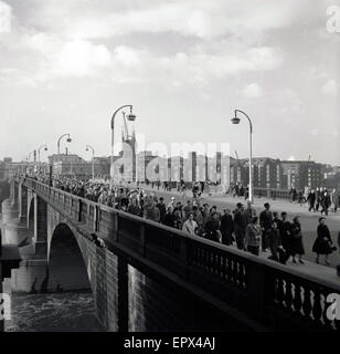 Années 1950, tableau historique, en regardant vers le sud, nous voyons les navetteurs marcher sur le pont de Londres, avec un nouveau quai d'Hibernia et à l'arrière-plan La cathédrale de Southwark, Londres, Angleterre, Royaume-Uni. Banque D'Images