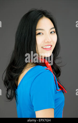 Jeune femme tournant asiatique retour isolé sur fond coloré Banque D'Images