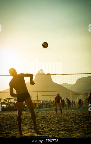 RIO DE JANEIRO, Brésil - février 01, 2014 : Jeune carioca brésiliens jouer une partie de beach-volley à posto 9 au coucher du soleil. Banque D'Images