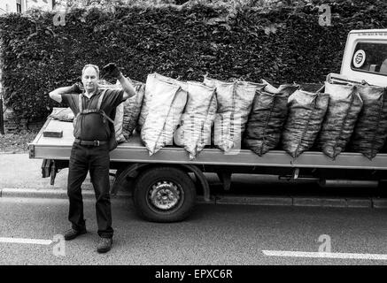 Charbon traditionnel livraison sacs homme ouvert du charbon de lorry Banque D'Images