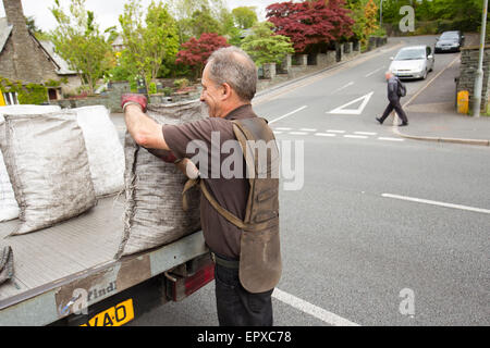 Charbon traditionnel livraison sacs homme ouvert du charbon de lorry Banque D'Images