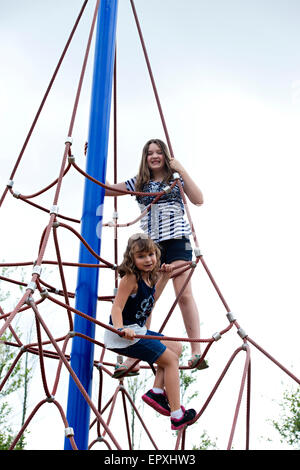 Les filles jouent sur corde à structure extérieur parc jeux pour enfants Banque D'Images