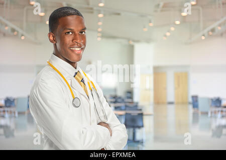 Portrait of young African American doctor smiling à l'intérieur du bâtiment de l'hôpital Banque D'Images