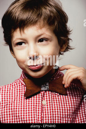 Peu cute boy dans bowtie smiling, Close up making funny faces Banque D'Images