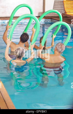 Les gens de la classe faisant l'aquaforme dans une piscine avec des nouilles Banque D'Images