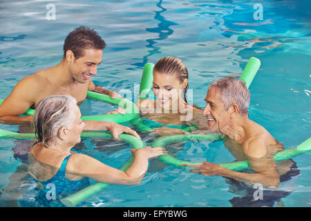 Famille heureuse avec couple dans l'eau de piscine Banque D'Images