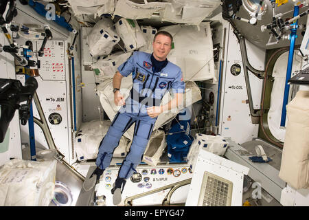 Le commandant de l'Expédition 43 et de l'astronaute de la NASA Terry Virts flotte autour d'une fonction de compression de pingouin à bord de la Station spatiale internationale le 12 mai 2015, dans l'orbite de la Terre. La combinaison prépare le corps des astronautes de retour à la gravité. Banque D'Images