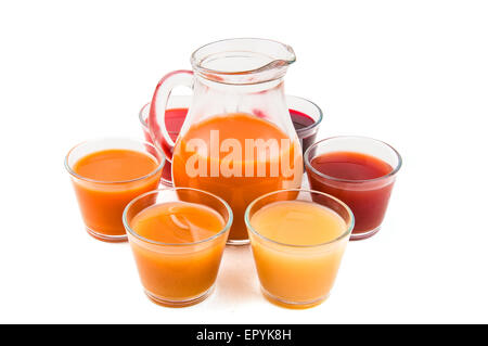 Pichet de jus organique avec six verres de variété de jus sur un fond blanc Banque D'Images