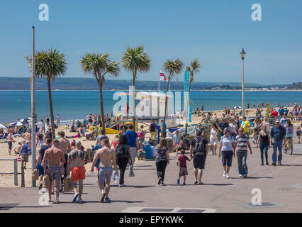 Les visiteurs bénéficiant du soleil sur la Promenade et plage de l'Ouest, Bournemouth, Dorset, England, UK Banque D'Images