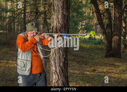 Objectif chasseur Senior fusil en forêt Banque D'Images