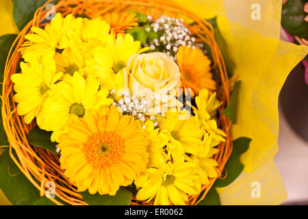 Un bouquet de gerberas jaunes et orange dans le panier Banque D'Images