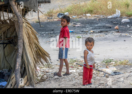 Les enfants sont à une cabane de stockage pour les articles recyclables recueillies par les pauvres à un dépotoir au Guatemala Banque D'Images