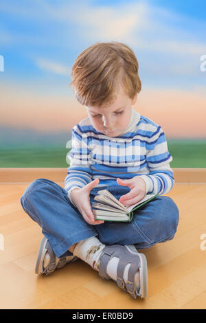 Boy reading book coin sur le sol et l'arrière-plan sunrise Banque D'Images