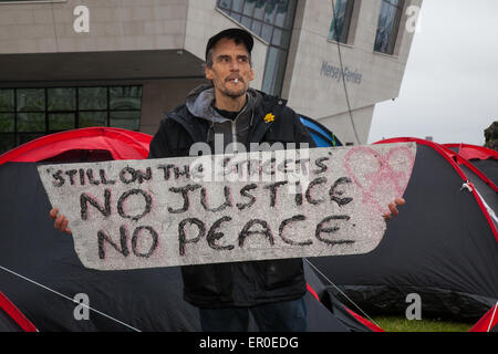 Les personnes sans domicile dans Liverpool, Merseyside, Royaume-Uni 24 Mai, 2015. M. Christopher Gandy   l'amour des activistes pour les sans-abri, qui ont occupé le bâtiment de la Banque d'Angleterre sur Castle Street jusqu'expulsés, ont érigé des tentes sur le quai dans la tête. Plusieurs nouvelles tentes ont été lancées, la création d'une horreur, sur une pastille verte dans le bâtiment entre Cunard et le terminal des ferries, avec des pancartes pour protester contre l'affichage sur des questions telles que les sans-abri, d'austérité et de l'évasion fiscale. Un signe très visible à l'avant du site dit "toujours dans la rue. Pas de justice, pas de paix." Banque D'Images