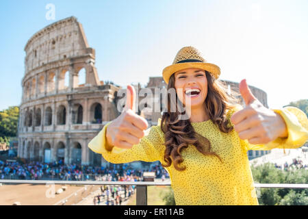 Un rire touriste est donné deux pouces vers le haut d'être un touriste à Rome. Dans la distance, le colisée et foules de touristes par une chaude journée d'été. Banque D'Images