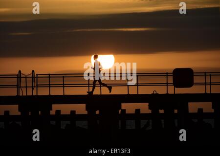 Météo France : Pays de Galles Aberystwyth UK Dimanche 24 Mai 2015 Un homme solo jogge en silhouette contre le soleil couchant sur la baie de Cardigan à la veille de la maison de banque mai lundi d'Aberystwyth, sur la côte ouest du pays de Galles Crédit photo : Keith morris / Alamy Live News Banque D'Images