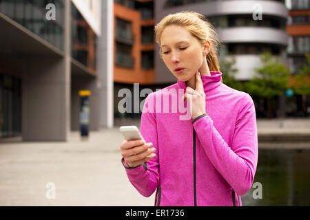 L'exercice de distribution femme son pouls sur son téléphone Banque D'Images