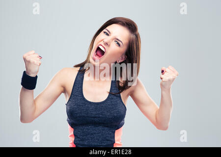 Jeune femme en colère sport crier sur fond gris et looking at camera Banque D'Images