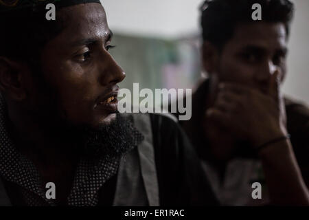 Langkawi, Malaisie. 20 mai, 2015. Muhammad Jamel (à gauche) il est représenté comme il parle de son histoire, il a 26 ans et il est arrivé ici à Langkawi il y a 10 ans, il est le premier sur qui est arrivé et il a acheté une carte DES NATIONS UNIES. Dans le quartier de Kuah, pas trop loin de la zone touristique de l'île de Langkawi, à proximité de l'aéroport.9 hommes Rohingyas ayant entre 15 et 26 ans, partager un plat à l'intérieur d'un bâtiment abandonné appartenant à leur employeur qu'ils travaillent pour.Après avoir fui leur pays (Myanmar) ''aidé'' par les contrebandiers habituellement à partir de la Thaïlande, et les dépenses pour certains d'entre eux plus de 10 mois t Banque D'Images