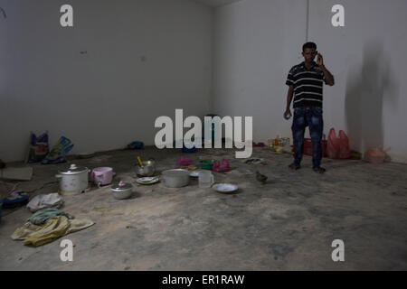 Langkawi, Malaisie. 20 mai, 2015. Norbashoor, il a 19 ans et il est arrivé ici à Langkawi il y a 1 an, il est représenté comme il debout dans la cuisine à l'intérieur de l'immeuble abandonné.dans le quartier de Kuah, pas trop loin de la zone touristique de l'île de Langkawi, à proximité de l'aéroport.9 hommes Rohingyas ayant entre 15 et 26 ans, partager un plat à l'intérieur d'un bâtiment abandonné appartenant à leur employeur qu'ils travaillent pour.Après avoir fui leur pays (Myanmar) ''aidé'' par les contrebandiers habituellement à partir de la Thaïlande, et les dépenses pour certains d'entre eux plus de 10 mois à voyager en bateau, ou à pied à l'intérieur Banque D'Images