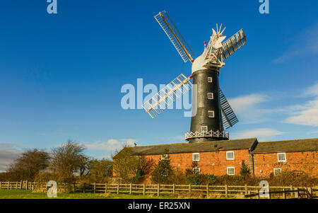 Moulin à vapeur Skidby qui sur une belle matinée d'hiver avec des cottages et des arbres près de la ville de Beverley, East Riding of Yorkshire, UK Banque D'Images