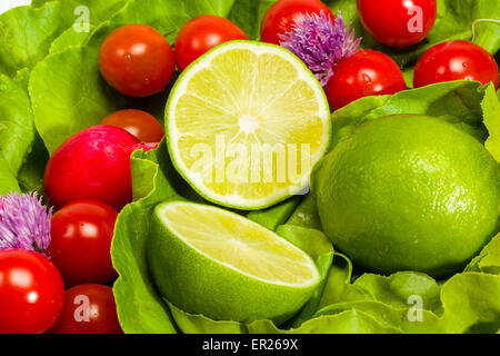 Laitue, radis, ciboulette, citron vert et tomates cerises Banque D'Images