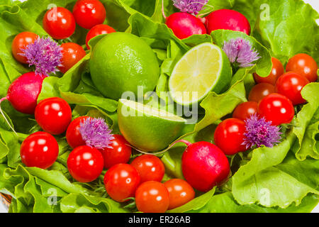Laitue, radis, ciboulette, citron vert et tomates cerises Banque D'Images
