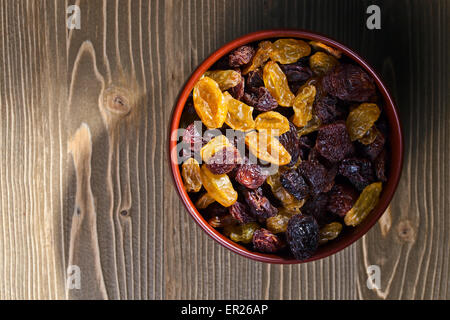Les raisins secs dans un brown dich on wooden table Banque D'Images