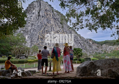 Thaïlande groupe de touristes admirant la vue de l'incrustation unique du laser de Bouddha à Khao Chee Chan montagne sacrée Pattaya Thaïlande S. E. Asie Banque D'Images