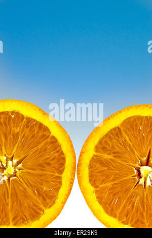 Deux moitiés d'une orange sur le fond dégradé blanc et bleu. High res photo prise avec un appareil photo plein cadre Banque D'Images