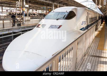 shinkansen japonais, train à grande vitesse, en attente à la plateforme de la gare de Shin-Osaka. Avant du train avec cabine conducteur et vue sur la plate-forme et le train. Banque D'Images