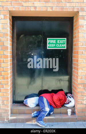 Femme sans-abri dort dans un shop doorway Banque D'Images