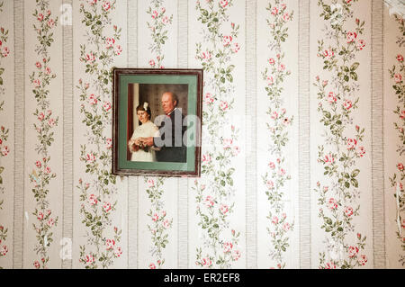 Photo de mariage accroché sur un mur avec un papier peint fleuri. Banque D'Images