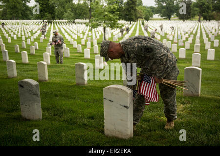 Un soldat de l'Armée américaine à partir de la vieille garde places drapeaux devant des lieux de sépulture en l'honneur du Jour du Souvenir au Cimetière National d'Arlington, le 21 mai 2015 à Arlington, en Virginie. La vieille garde a mené dans des pavillons, quand un drapeau américain est placé à chaque pierre tombale, depuis 1948. Banque D'Images