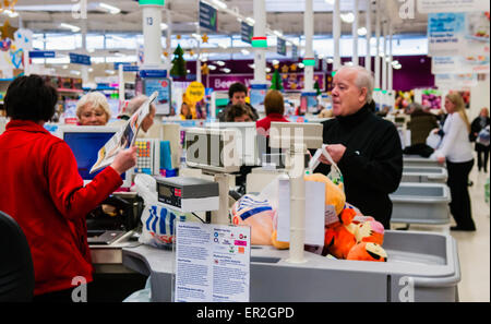 Les clients à la caisse d'un magasin Tesco. Banque D'Images