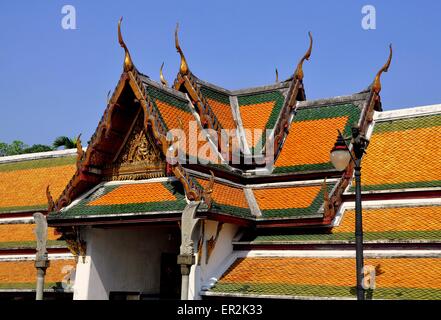 Bangkok, Thaïlande : toit à pignon en flèche avec ornements dorés chofah sur la galerie du cloître à Wat Suthat Banque D'Images