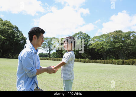 Heureux père japonais et son fils dans un parc de la ville Banque D'Images