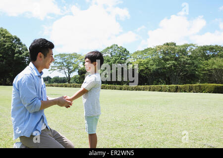 Heureux père japonais et son fils dans un parc de la ville Banque D'Images