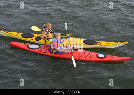 Merrick du sud, New York, USA. 24 mai, 2015. Un jeune homme et femme sont kayak en Merrick Bay le long de la rive sud du parc de prélèvement et conservation au cours du week-end du Memorial Day. Le kayak rouge et jaune Caroline avait kayak avait écrit sur Montauk leurs arcs. © Ann Parry/ZUMA/Alamy Fil Live News Banque D'Images