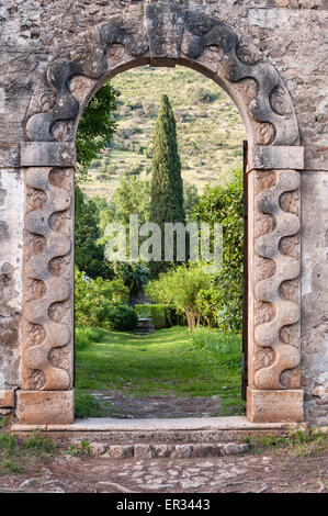 Ninfa, Latina, Latium, Italie. Un jardin romantique situé dans les ruines d'un village médiéval. La porte dans le jardin de citron Banque D'Images