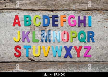 L'alphabet en bois coloré situé sur grunge background. Banque D'Images