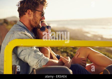 Portrait de beau jeune couple assis ensemble dans une voiture en souriant un jour d'été. Jeune couple romantique appréciant les chaque ot Banque D'Images