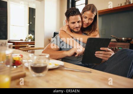 Tourné à l'intérieur de young caucasian couple dans la cuisine le matin et à l'aide d'une tablette numérique ensemble. Banque D'Images